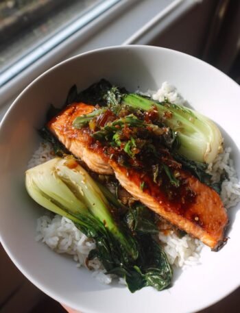 Asian-style glazed salmon bowl with bok choy and rice.