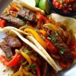 Steak fajitas with sautéed onions and peppers.