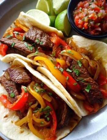 Steak fajitas with sautéed onions and peppers.